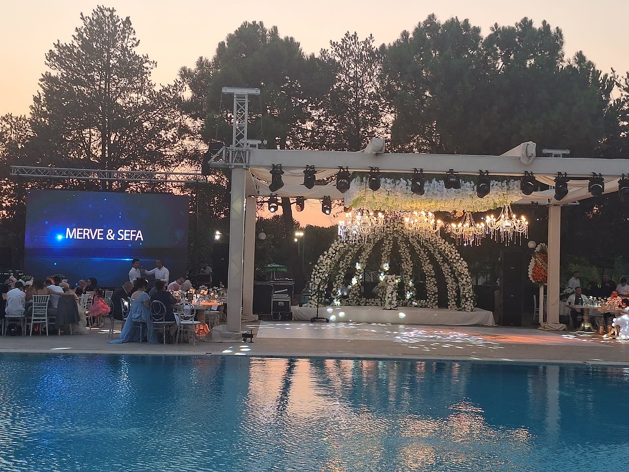 Gece düğün sahnesi, çiçek kemeri ve dans pisti; Emex Hotel havuzbaşı